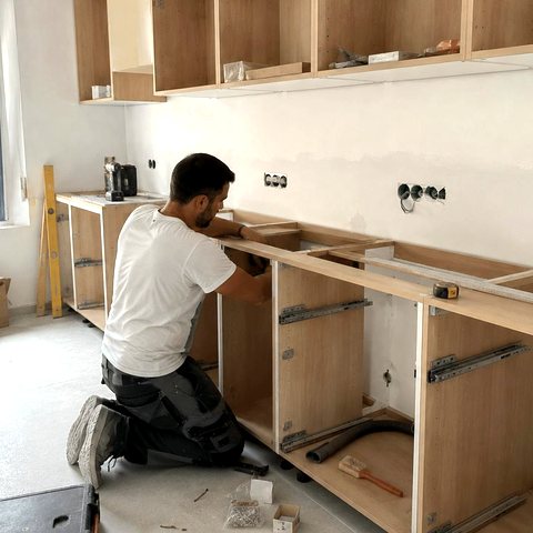 Artisan Hservices75 posant les meubles d'une cuisine équipée à Paris